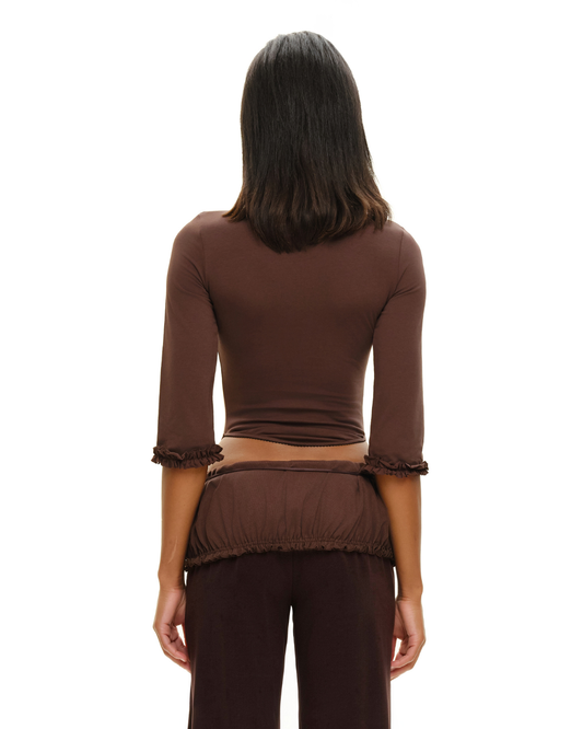 Brown long-sleeve top from back with gathered cuffs and ruched waistband hem