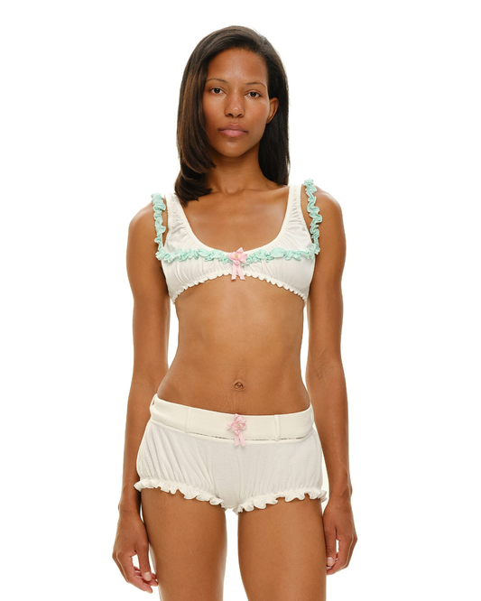 White rosette-trim shorts with mint ruffle edges and scalloped waistband hem