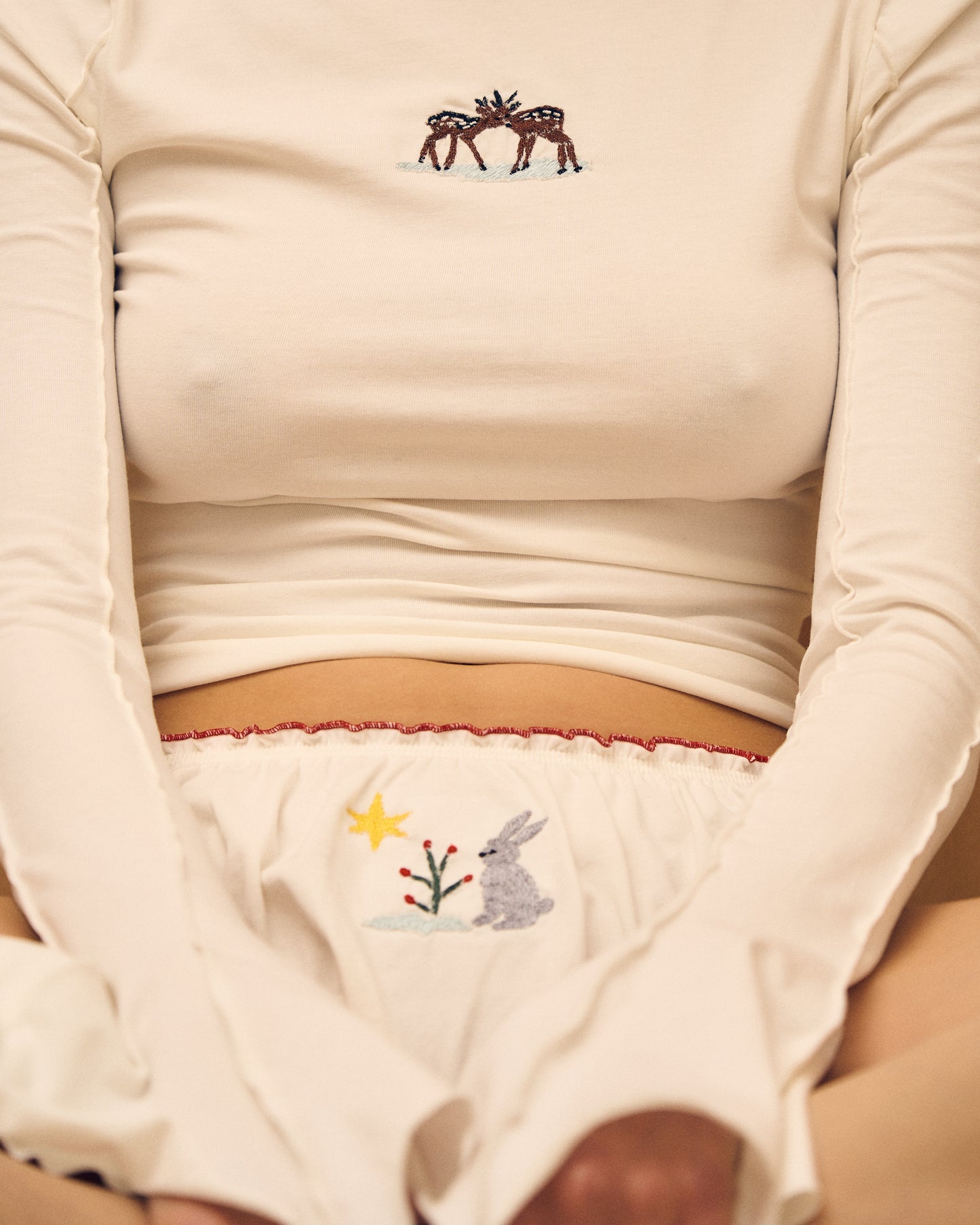 White tanga panties close-up of bunny embroidery and red picot-trim waistband