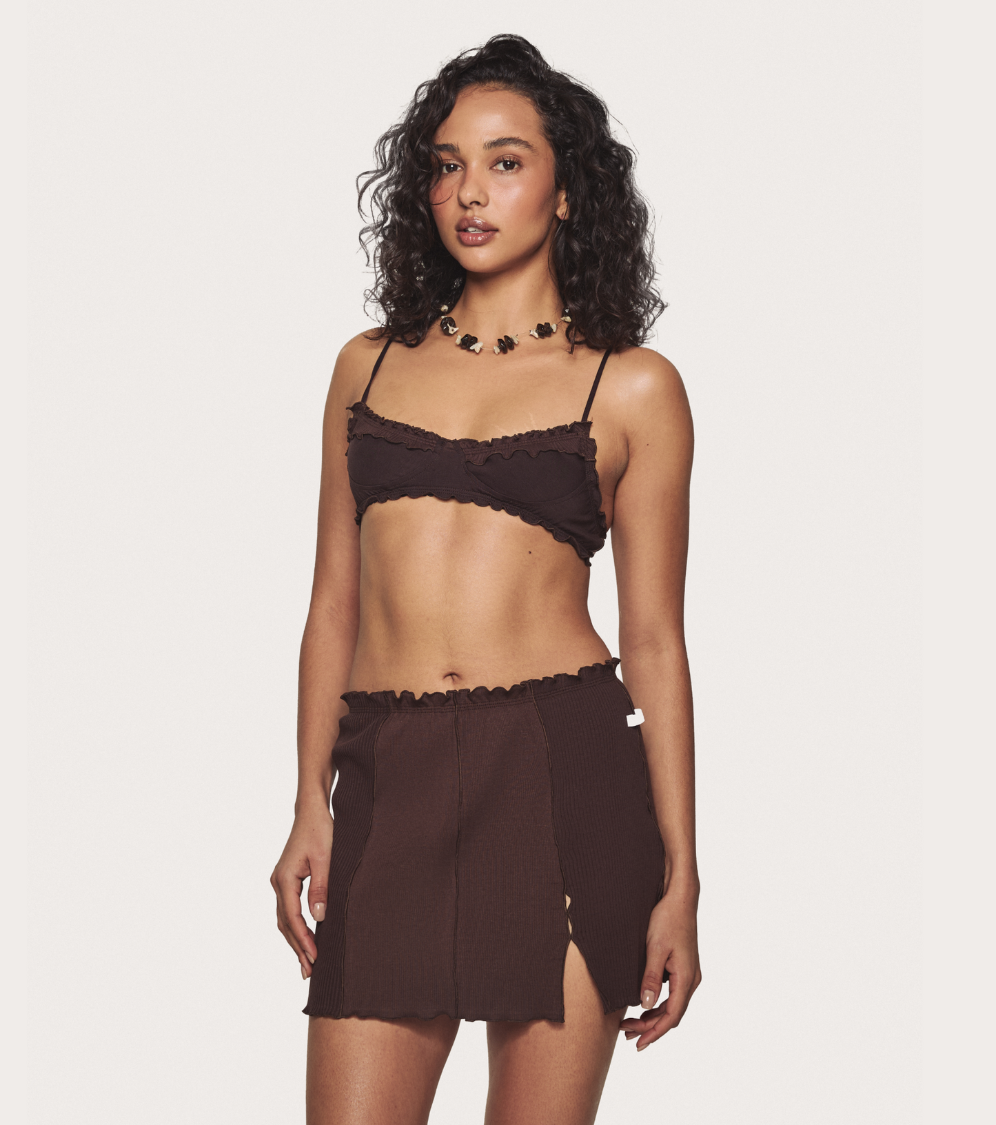 Brown wavy mini skirt on-model with elastic waist and side slit