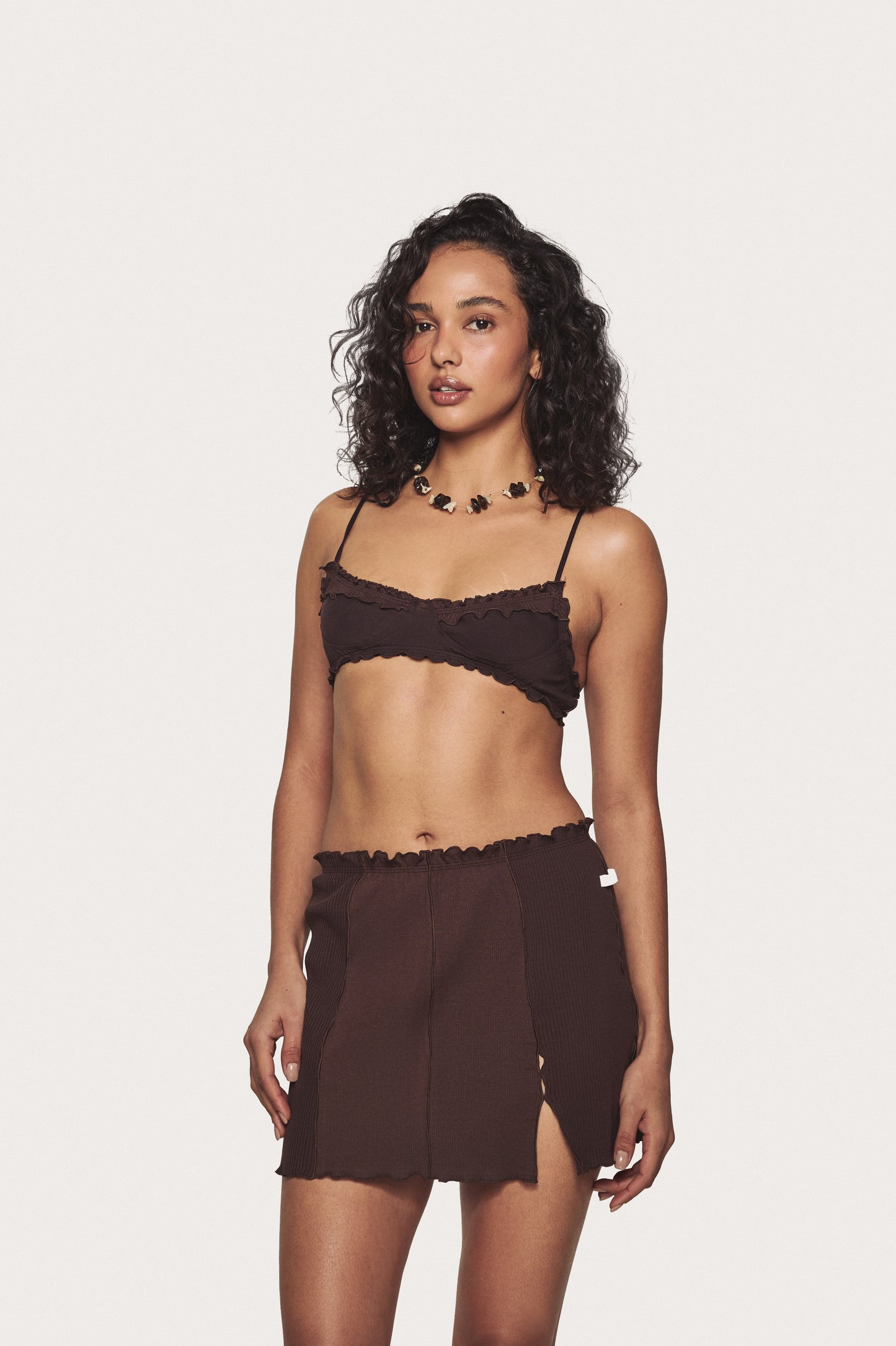 Brown wavy bralette with ruffled edge and slim spaghetti straps, on model
