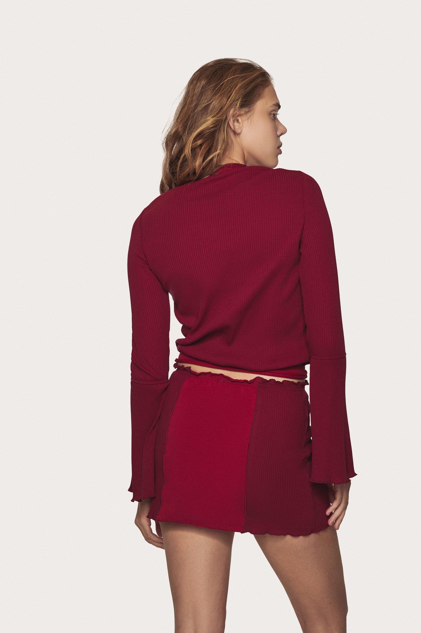 Burgundy wavy mini skirt back view, elastic waist and scalloped ruffle hem