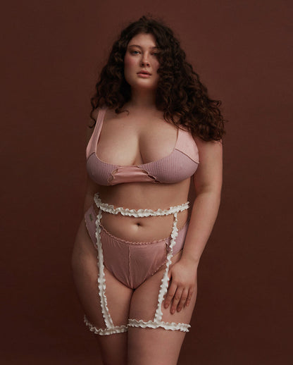 Pink thong with ribbed panels and scalloped trim, full back on model