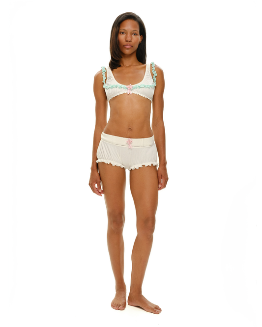 White shorts with mint ruffle trim, pink rosette detail, scalloped hem