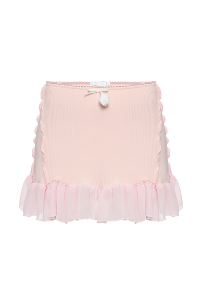 Pink ribbed skort with scalloped ruffle trim and bow detail at the waistband.