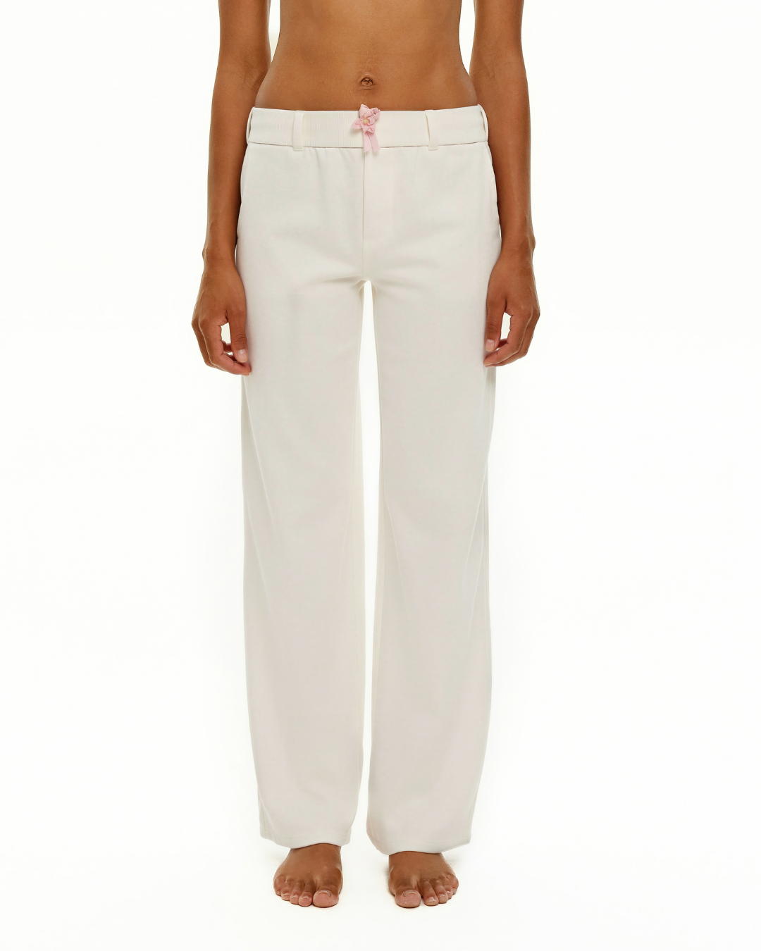 White wide-leg trousers with pink ribbon bow at waist