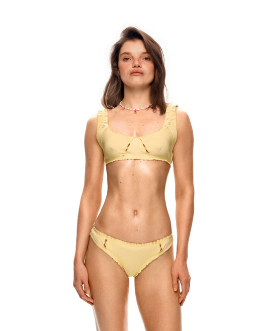 Yellow bralette top on model, scoop neckline and ruffled wide straps