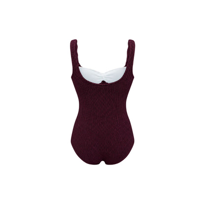One-piece swimsuit, dark maroon textured knit, scoop neckline and high leg.