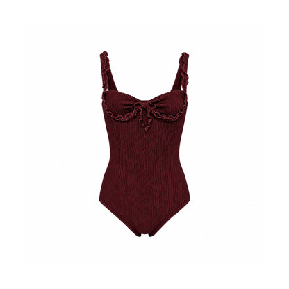 One-piece swimsuit in dark burgundy with ruffled wave trim and bow at bust