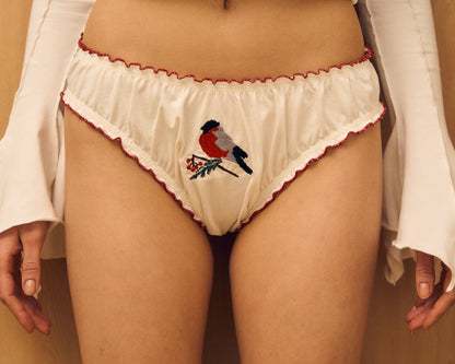 White tanga panties with red trim and bird embroidery on the front
