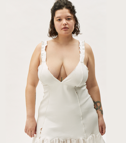 White sleeveless mini dress with V-neck, fitted waist, and ruffled hem