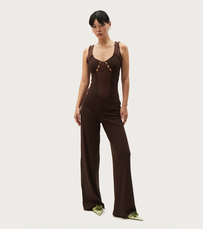 Brown wavy-rib bodysuit with scoop neck and front cutout lace-up, worn with pants