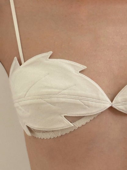 White bra cup close-up with leaf applique and stitched seams