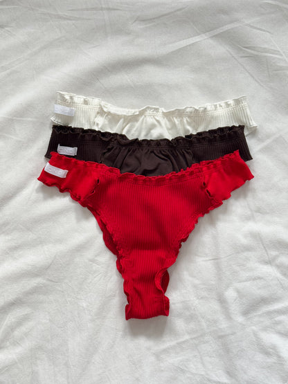 Three-pack tanga panties in white, dark brown, and red ribbed knit