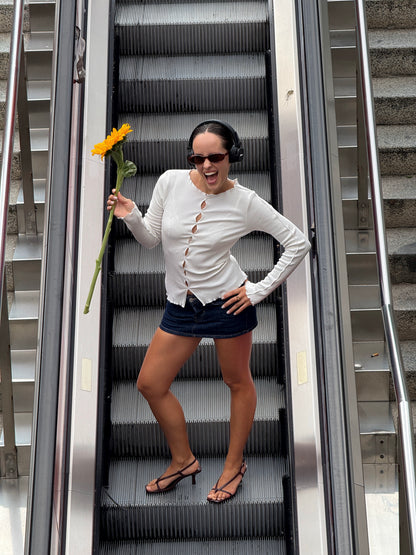 White long-sleeve ribbed top with oval cutouts down the front and round neckline