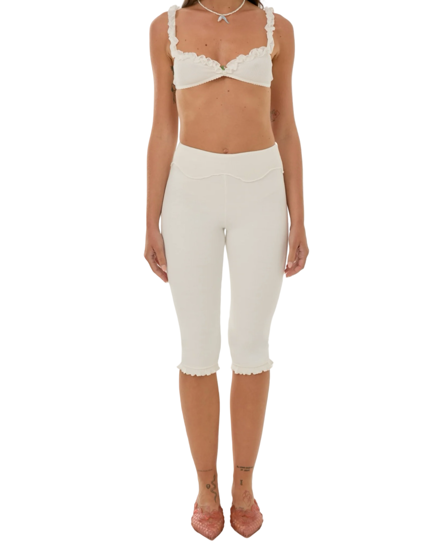 White capri pants with wavy waistband and scalloped cuffs at the knee.