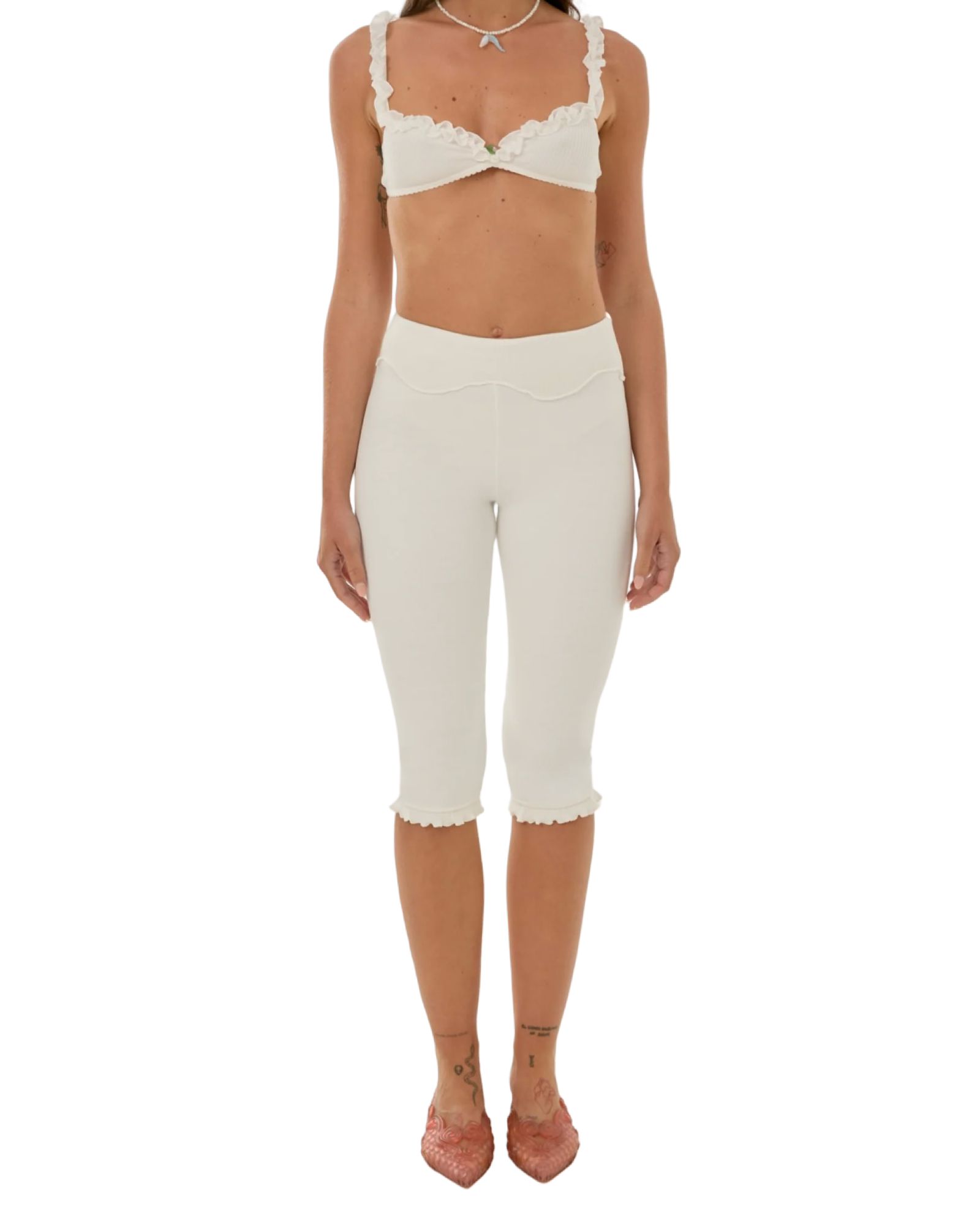 White capri pants with wavy waistband and scalloped cuffs at the knee.