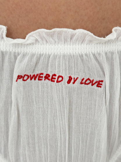 White tanga panties with red “POWERED BY LOVE” text on the front