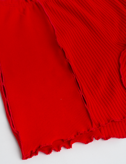 Red ribbed knit shorts fabric with stitched seams and scalloped hem edge