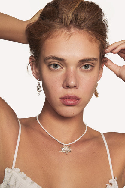 Star pendant necklace with white beaded chain and crystal star charm, on model