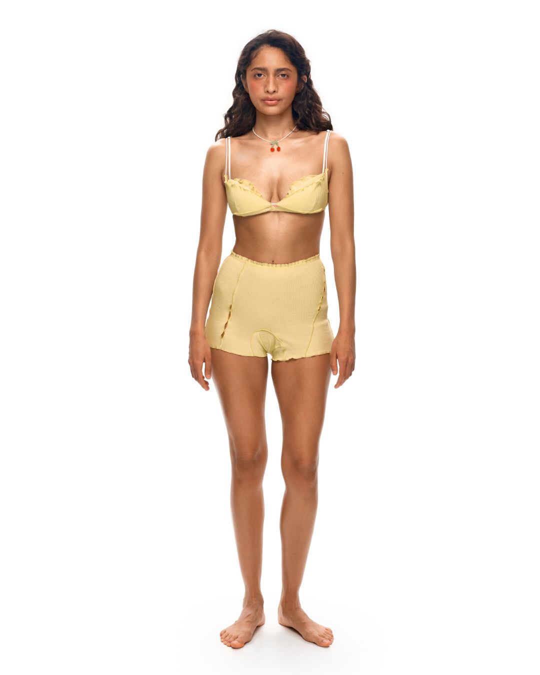 Pale yellow layered underwire bra and matching shorts set with thin straps and lace trim