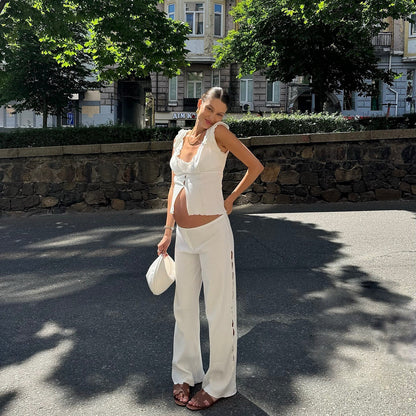 White short wavy tank with ruffled shoulder edges and V-neck tie-front detail.